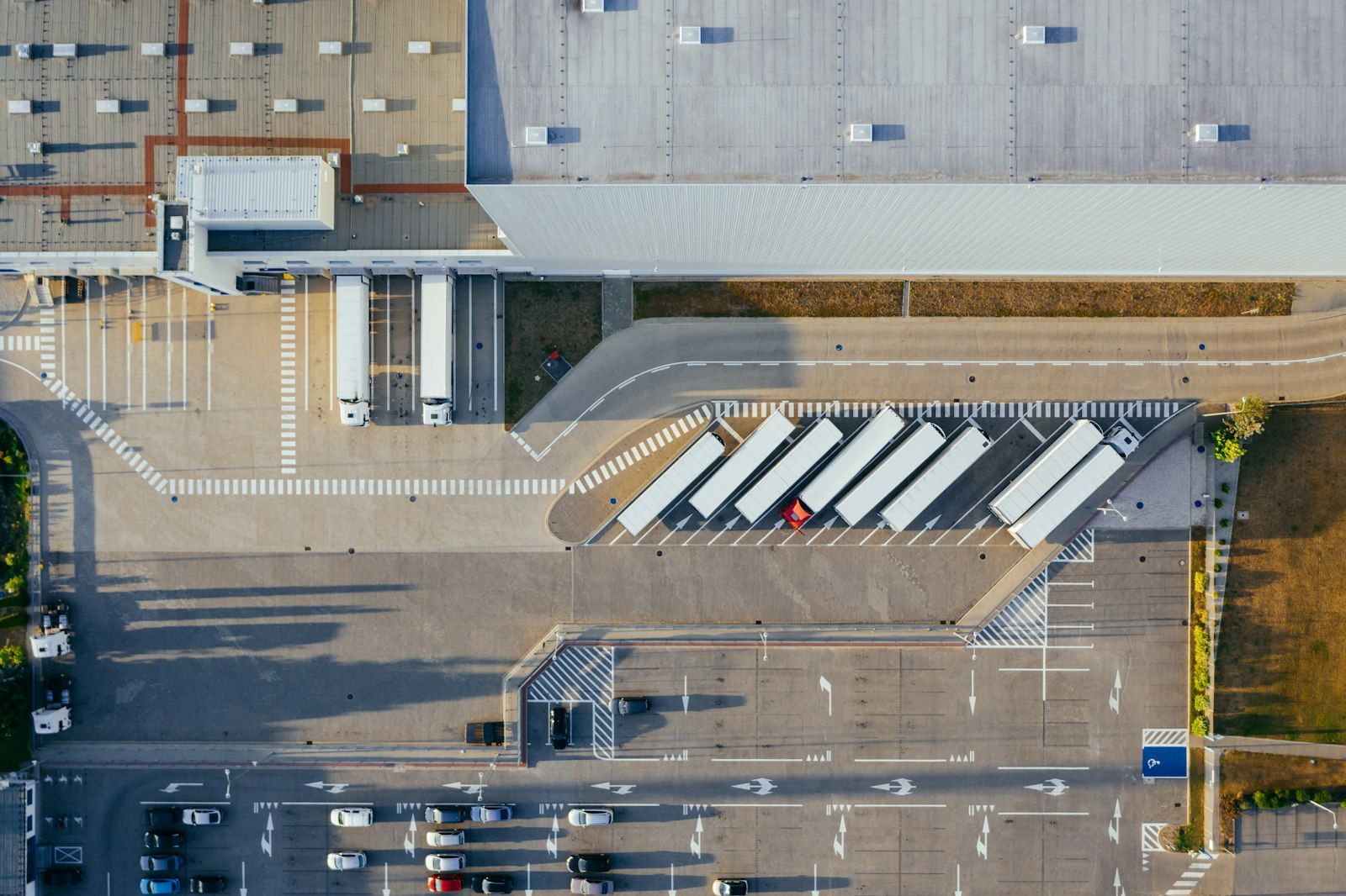 Modern distribution warehouse with loading docks and parked delivery trucks at dusk
