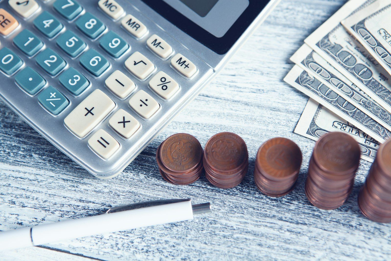 Calculator, house keys and printed loan documents spread across a wooden desk